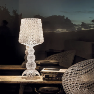 A dimly lit room with a Mini Kabuki Table Lamp by Kartell in Transparent Crystal